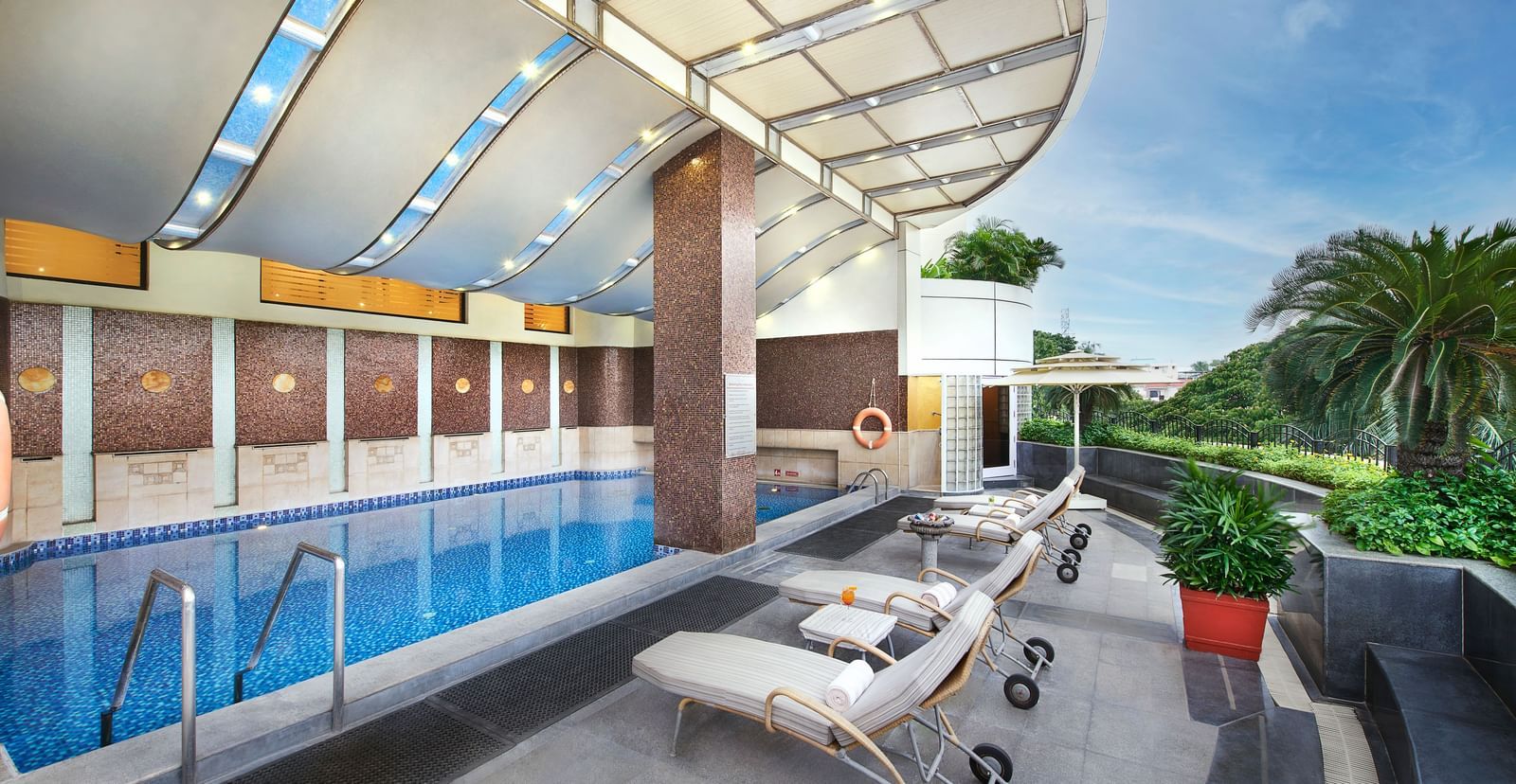 An image of a swimming pool in a building with lounger beds near it at Accord Hotels and Resorts, one of the 5 star hotels in T Nagar with a swimming pool.